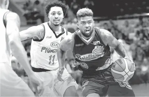  ??  ?? Maverick Ahanmisi of the Rain or Shine Elasto Painters goes hard to the basket against Rashawn McCarthy of Kia Picanto during their game last night at the Cuneta Astrodome.