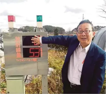  ??  ?? Professor Dr Ng Kwan Hoong standing beside a radiation indicator installed 32km away from the Fukushima Daiichi Nuclear Power Plant in 2013.