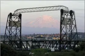  ?? AP PHOTO/TED S. WARREN ?? In this May 7, 2018 photo, Mount Rainier is seen at dusk and framed by the Murray Morgan Bridge in downtown Tacoma, Wash. The eruption of the Kilauea volcano in Hawaii has geologic experts along the West Coast warily eyeing the volcanic peaks in...