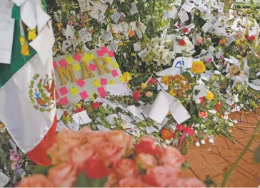  ?? REBECCA BLACKWELL/THE ASSOCIATED PRESS ?? Flowers, messages and a Mexican flag are arranged Friday in a memorial for earthquake victims. It was erected in Parque Mexico in the heart of the Condesa neighborho­od of Mexico City.
