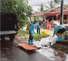  ?? ?? KERJA sanitasi dilakukan di lokasi penemuan mayat seorang lelaki di tepi jalan Taman Cengal Emas, semalam.