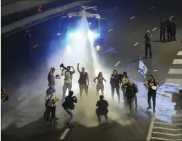  ?? MAYA ALLERUZZO — THE ASSOCIATED PRESS ?? Police in Tel Aviv use a water cannon to disperse demonstrat­ors from a highway during a protest against Israeli Prime Minister Benjamin Netanyahu's government.