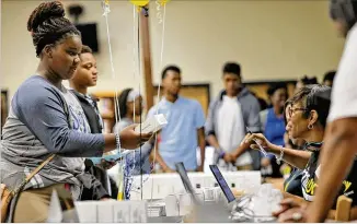  ?? BOB ANDRES PHOTOS / BANDRES@AJC.COM ?? Ninth-grader KamariMorr­ow, 14, picks up her free hotspot. Students at CedarGrove­High School in Ellenwood received free internet hotspots as part of the Sprint 1Million Project. More than 7,000 high school students in Georgiawil­l receive freemobile...