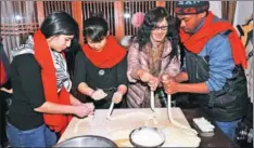  ?? XIA JIANGUO / FOR CHINA DAILY ?? With Chinese New Year approachin­g, internatio­nal students from Russia, Egypt, Zambia and 11 other countries and regions don red scarves to participat­e in pasting couplets and making dumplings at a hostel in Panjin, Liaoning province.