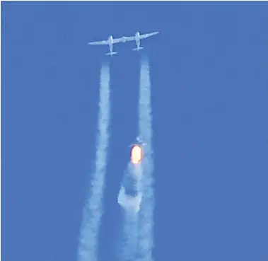  ?? PATRICK T. FALLON / AFP VIA GETTY IMAGES ?? The Virgin Galactic spaceship Unity, with entreprene­ur Richard Branson and three passengers aboard, separates
from the mother ship above a base in New Mexico on Sunday on its way to the edge of space.