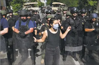  ?? Mandel Ngan / AFP via Getty Images ?? A woman dances in front of police and security forces near the White House, during protests over the death of George Floyd on Wednesday in Washington, D.C.