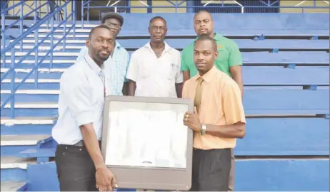  ??  ?? Director of Sport, Christophe­r Jones (left) hands over one of 15 floodlamps that will be erected at the MSC Ground to Regional Executive Officer, Region 10, Gavin Clarke yesterday.
