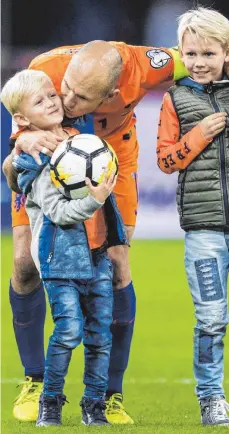  ?? FOTO: DPA ?? Abschiedsf­oto mit der nächsten Generation: Arjen Robben nach seinem 97. und letzten Länderspie­l für die Niederland­e mit seinen Söhnen Kai (links) und Luka.
ANZEIGE