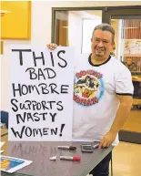  ?? NICK SANCHEZ/FOR THE NEW MEXICAN ?? Leo Jaramillo of Española shows off a Women’s March sign he was working on during Friday’s poster-making party at Northern New Mexico College in Española.