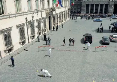  ??  ?? Polizia scientific­a I rilievi sul lato di piazza Colonna dove sono stati esplosi i colpi di pistola che hanno ferito i militari (Proto)