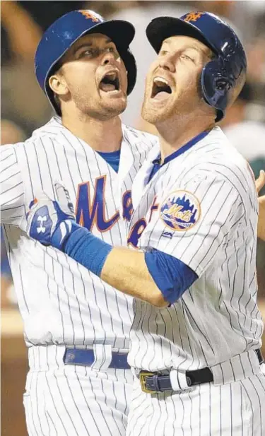  ?? AP ?? Todd Frazier (r.) and J.D. Davis celebrate after Frazier hits three-run homer to tie game during ninth inning on Friday night as Mets win thriller at Citi Field.