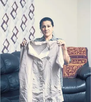  ?? CHRISTOPHE­R GREGORY PHOTOS THE NEW YORK TIMES ?? Sandra Diaz holds her housekeepi­ng uniform from her time at the Trump National Golf Club. Diaz said she was undocument­ed then, but has since gained legal residence.