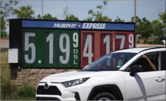  ?? DAVID ZALUBOWSKI — THE ASSOCIATED PRESS ?? Gasoline prices are displayed outside a convenienc­e store as a motorist drives by on Thursday in Thornton, Colo. Americans have been able to keep spending, despite higher inflation, because of rising wages, a stockpile of savings built up during the pandemic and a rebound in credit card use.