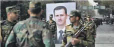  ?? AFP ?? Soldiers around a portrait of President Bashar Al Assad on the first anniversar­y of retaking Aleppo in December last year