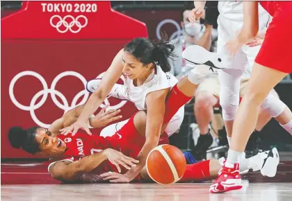  ?? NATHAN DENETTE/THE CANADIAN PRESS ?? Team Canada forward Miranda Ayim, left, battles for the ball against Team Serbia forward Jelena Brooks during the teams' opening Olympic contest Monday at the Saitama Super Arena in Tokyo. Serbia won 72-68, putting Canada in a precarious position.