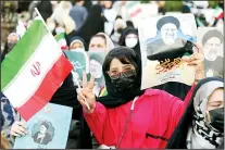  ?? (AP) ?? A supporter of presidenti­al candidate Ebrahim Raisi holds up a picture of him and an Iranian flag as she flashes the victory sign while attending a rally in Tehran, Iran, June 14. Iran’s clerical vetting committee has allowed just seven candidates on Friday’s ballot, nixing prominent reformists and key Rouhani allies. The presumed front-runner has become Raisi, the country’s hard-line judiciary chief who’s closely aligned with Supreme Leader Ayatollah Ali Khamenei.