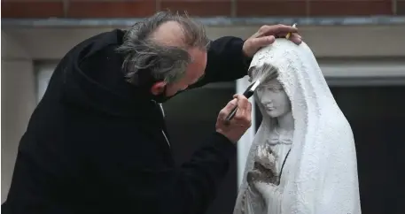  ?? NAncy lAnE PHoToS / HErAld STAFF ?? A LITTLE TOUCH-UP: Paul Marcouilli­er, who volunteers at St. Monica-St. Augustine Church in South Boston, repairs a statue of the Virgin Mary that was vandalized.