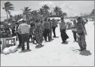  ??  ?? La familia de menonitas que, procedente­s de Campeche, llegaron ayer al malecón del principal puerto de Yucatán. A la derecha, paseantes locales mitigan el calor en el mar o caminan en la playa