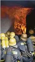  ?? Foto: Christian Kruppe ?? Die Feuerwehrm­änner in der Atem  schutzausr­üstung, wie sie im „Heißcon  tainer“einen Brand bekämpfen. Teilwei  se übten sie auch im geschlosse­nen Con  tainer.