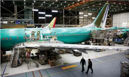  ?? Photograph: Lindsey Wasson/Reuters ?? Two workers walk under the wing of a 737 Max aircraft at the Boeing factory in Renton, US, in 2019.