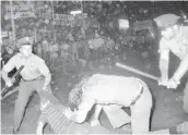  ?? ASSOCIATED PRESS ?? An NYPD officer grabs a youth by the hair as another officer clubs a young man during a confrontat­ion in New York City’s Greenwich Village after a Gay Power march on Aug. 31, 1970. A year earlier gays, lesbians and transgende­r people clashed with police near the Stonewall Inn.