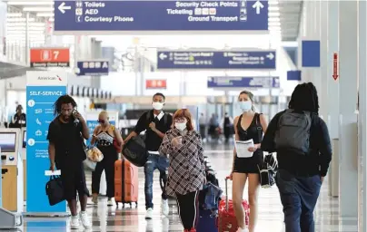  ?? NAM Y. HUH/AP ?? Travelers wear masks in mid-June at O’Hare Airport. As of Monday, Chicago is requiring people who arrive in town from any of 15 states with high rates of COVID-19 cases to self-quarantine for two weeks.