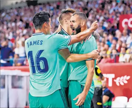  ??  ?? Real Madrid striker Karim Benzema (right) celebrates his goal against Sevilla in their La Liga game at Estadio Ramon Sanchez Pizjuan in Seville on Sunday.
GETTY IMAGES