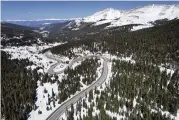  ?? BRITTANY PETERSON / AP ?? A road winds through the Rocky Mountains. Some droughtpro­ne communitie­s in the U.S. West are mapping snow by air to refine their water forecasts.