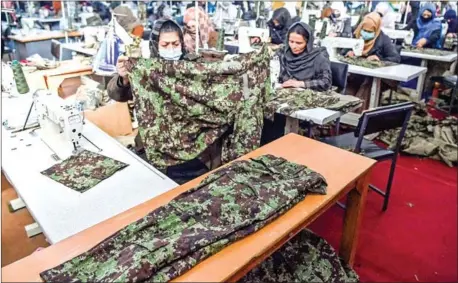  ?? AFP ?? Women who lost their husband or relatives in the ongoing war in Afghanista­n with the Taliban stitch military uniforms at a factory in Kabul.