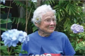  ?? PHOTO COURTESY OF SARAH NETTER ?? Competitiv­e sprinter Julia Hawkins, 101, wearing a flower in her garden.