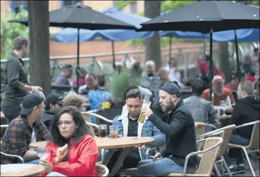  ?? JON SUPER — THE ASSOCIATED PRESS FILE ?? Members of the public are seen July 4at a bar on Canal Street in Manchester’s gay village, England. The country is embarking on perhaps its biggest lockdown easing yet as pubs and restaurant­s have the right to reopen for the first time in more than three months. In addition to the reopening of much of the hospitalit­y sector, couples can tie the knot once again, while many of those who have had enough of their lockdown hair can finally get a trim.