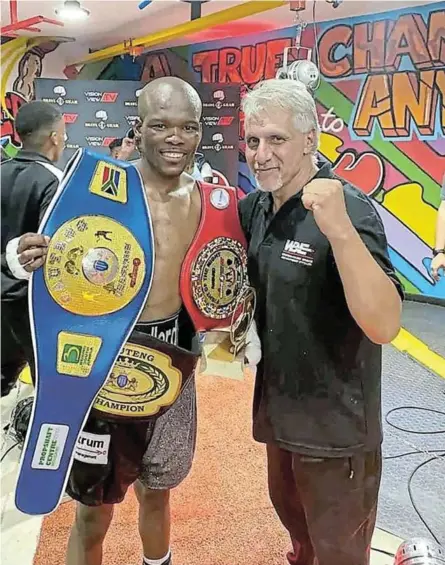  ?? /MONWABISI JOMLONGO ?? Newly crowned Gauteng junior featherwei­ght champ Vusi Ngcamu shows off his belts with his trainer Alan Toweel Junior.