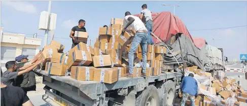  ?? Picture: AP ?? Left: Palestinia­ns loot a truck with humanitari­an aid near the Rafah border crossing in the Gaza Strip.