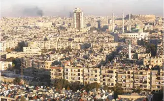  ?? — AFP ?? ALEPPO: A general view taken from the government-held side of the city shows smoke billowing during fighting between Syrian regime forces and rebel fighters in east Aleppo yesterday.