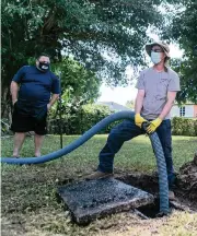  ?? MATIAS J. OCNER mocner@miamiheral­d.com ?? Jeremy Langford, center, of AA ARON Super Rooter, cleans a septic tank while homeowner Ray Alvarez looks on.