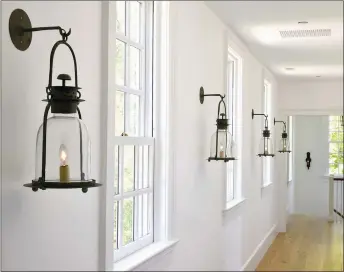  ??  ?? The upstairs hallway is lined with hanging hurricane lanterns from Lars Bolander.