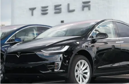  ?? AP PHOTO ?? A 2018 Tesla Model X electric vehicle sits on display outside a Tesla showroom in Littleton, Colo.