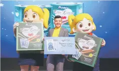  ??  ?? Chia (centre) and Julie’s mascots are seen in a photo-call during the launch campaign for ‘Titipkan Luahan Kasih Anda 2017’ and the limited edition Raya packaging Love Letters.