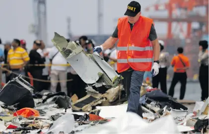  ?? Picture: Reuters ?? PUZZLE. A man from the National Transporta­tion Safety Board examines debris from Lion Air flight JT610 at Tanjung Priok port in Jakarta yesterday.