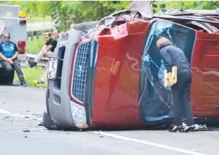  ??  ?? LA FISCAL María del Mar Ortiz revisa la guagua Ford Explorer en que viajaba siete personas, incluyendo tres niños, y que resultaron todos con diferentes lesiones.