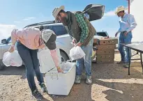  ??  ?? Chico Basin Ranch director of business developmen­t Tess Leach, left, and her brother, general manager Duke Phillips IV, load local beef into bags to give to needy families.