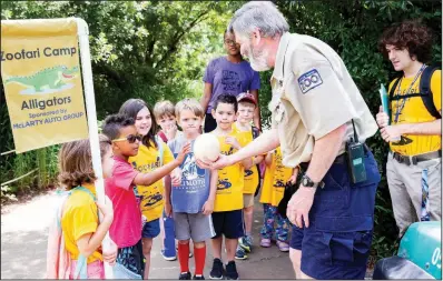  ?? (Courtesy of the Little Rock Zoo) ?? A zookeeper shows an egg to campers at the Little Rock Zoo’s Zoofari Camp in 2019.
