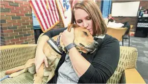  ??  ?? Sarah Sell, director of veteran student services at Wichita State University, cuddles with her rescue dog Riley, which she is training to be a therapy dog. — TNS