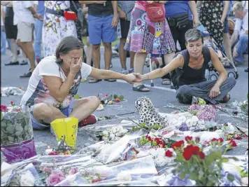  ?? FRANCOIS MORI / AP ?? People pay tribute to the victims at the site of a deadly truck attack on the famed Promenade des Anglais in Nice, France, on Saturday. French Interior Minister Bernard Cazeneuve says that the truck driver who killed 84 people when he careened into a...