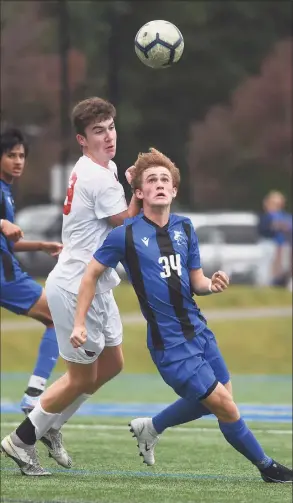  ?? Dave Stewart / Hearst Connecticu­t Media ?? Darien’s Matthew Kennedy (34) and Greenwich's Jamie Smith battle for a ball in the air during Tuesday’s game at Darien High School.