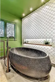  ?? DESIGNED BY: NATALIE DU BOIS. ?? Matte and gloss fan tiles are teamed with a crushed marble bathtub and vanity top in this NKBA award-winning bathroom.