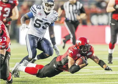  ?? ARYN TOOMBS/ CALGARY HERALD ?? Calgary back Jon Cornish, bottom, stretches out for a few more yards during CFL action at McMahon Stadium on Monday night. A reader writes to say officials are calling too many penalties and are ruining the flow of the game.