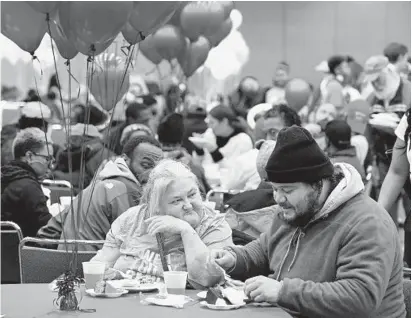  ?? KENNETH K. LAM/BALTIMORE SUN PHOTOS ?? Linda Stevens and her son, Michael, enjoy a Thanksgivi­ng meal at the 63rd Thanksgivi­ng Dinner &amp; Resource Fair Wednesday at the Baltimore Convention Center, put on by Goodwill Industries. Besides food, the fair offered informatio­n on free community resources.