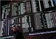  ?? JOHN LOCHER — THE ASSOCIATED PRESS ?? A man walks by as betting odds Feb. 3for Super Bowl 55 are displayed on monitors at the Circa resort and casino sports book in Las Vegas.