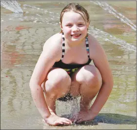  ??  ?? Water: Seven-year-old Gracelyn Fennel plays in the water while attending opening day for the Playscape Splash Pad at the Murphy Arts District on Friday.